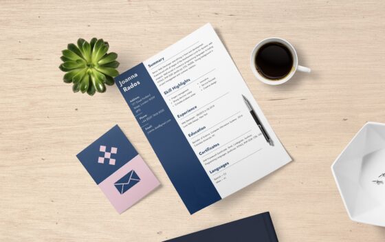 Resume with white and blue columns in the center of a light brown table.